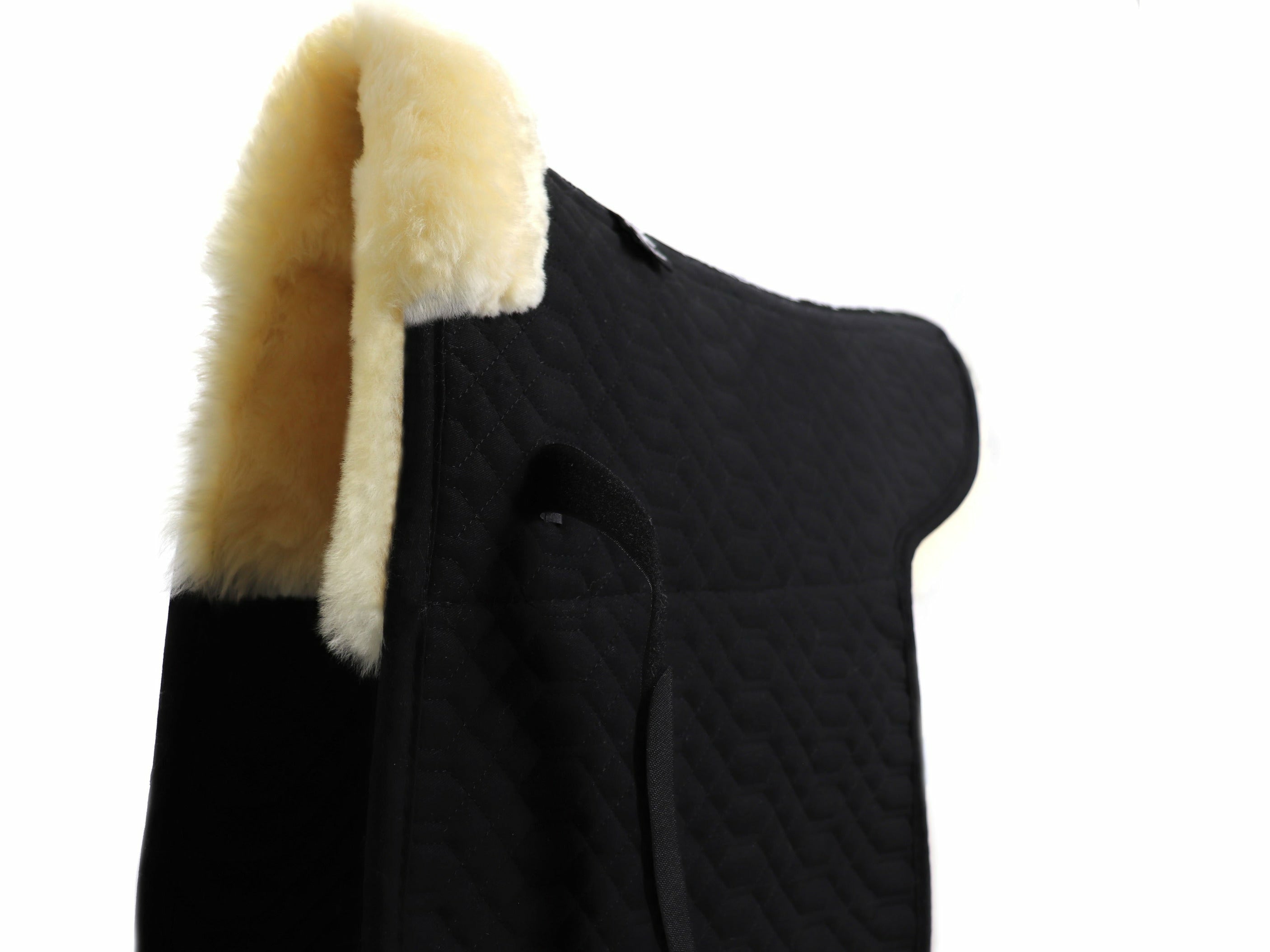 Die hochwertige Satteldecke aus Baumwolle und 100% australischem Merino Lammfell schont Isi und Reiter. Die komfortable Sattelunterlage mit Fell im Sattelsitzbereich und Fellkranz vorne ist speziell für Islandpferde entwickelte wurden.